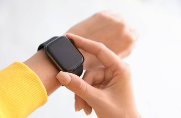 istock Woman checking stylish smart watch on light background, closeup 1368918675