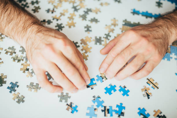 istock Hands sorting through the pieces of the puzzle in search  solution 1368920116