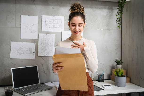 One woman front view portrait of young adult female holding and opening envelope with letter reading good news hired for work offered contract or winning scholarship or grant for project copy space One woman front view portrait of young adult female holding and opening envelope with letter reading good news hired for work offered contract or winning scholarship or grant for project copy space Scholarship stock pictures, royalty-free photos & images