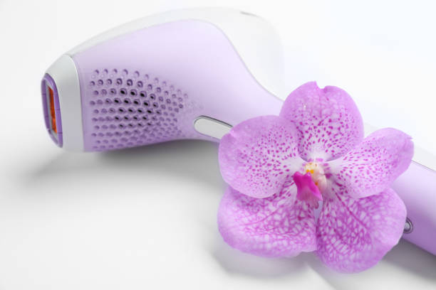 Modern photoepilator and orchid flower on white background, closeup Modern photoepilator and orchid flower on white background, closeup epilator stock pictures, royalty-free photos & images