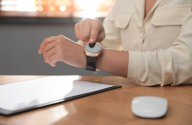 istock Woman using modern smart watch in office, closeup 1368920793