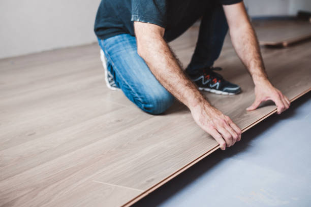 istock The master mounts the laminate on the floor - a long row  joins the previous one 1368921735