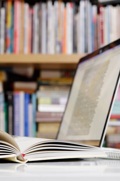 istock Close up of open book and  laptop computer at the library 1368922476