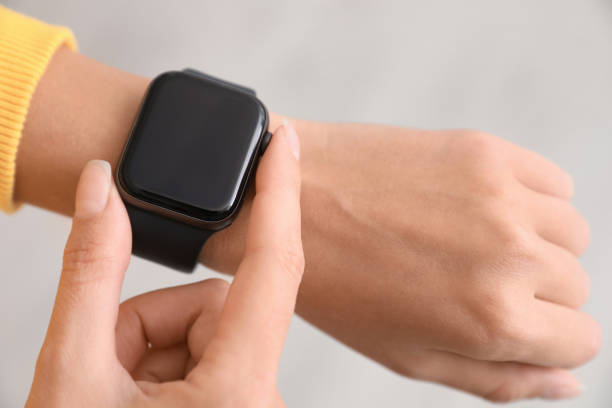 istock Woman checking stylish smart watch on light background, closeup 1368923417