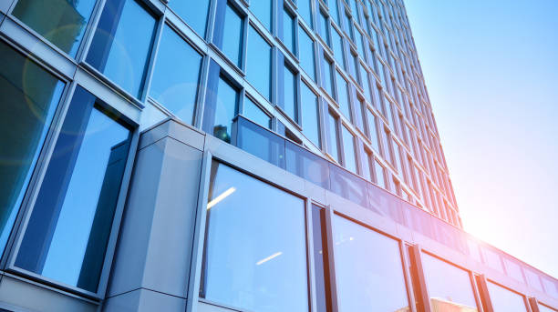 istock Commercial building close up in blue tone. Gigantic skyscraper from below. 1368923585