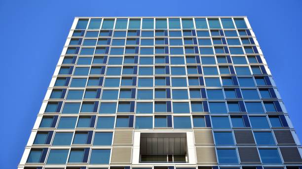 istock Commercial building close up in blue tone. Gigantic skyscraper from below. 1368923645