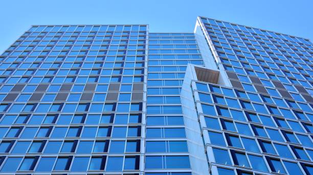 istock Commercial building close up in blue tone. Gigantic skyscraper from below. 1368923665
