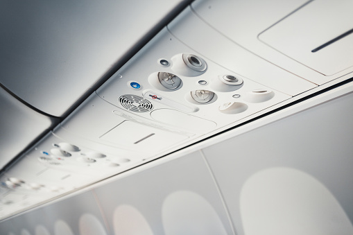 Upper panel with controls for ventilation, lighting, and a steward call for passengers in the aircraft cabin - a view of the airliner interior