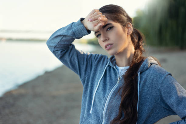 istock Tired woman runner taking a rest after running hard on beatch 1368923921