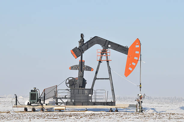 Pumpjack Pumpjack in a winter landscape, Alberta,Canada. oil pump oil industry alberta equipment stock pictures, royalty-free photos & images