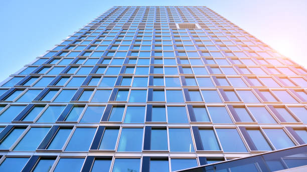 istock Commercial building close up in blue tone. Gigantic skyscraper from below. 1368925796