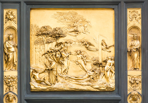 FLORENCE, ITALY - MAY 10, 2019: Lorenzo Ghiberti's Gate of Heaven, Creation of Adam and Eve, The Fall, Exile from Paradise. gate panel