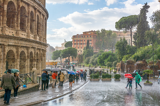 Rome, Italy - Oct 06, 2018: Heavy rain, tourists under umbrellas, the Colosseum is the tourist center of Rome.