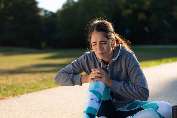 Young sporty woman has knee pain stock photo
