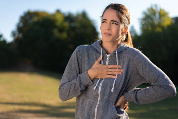 Young sporty woman has chest pain stock photo