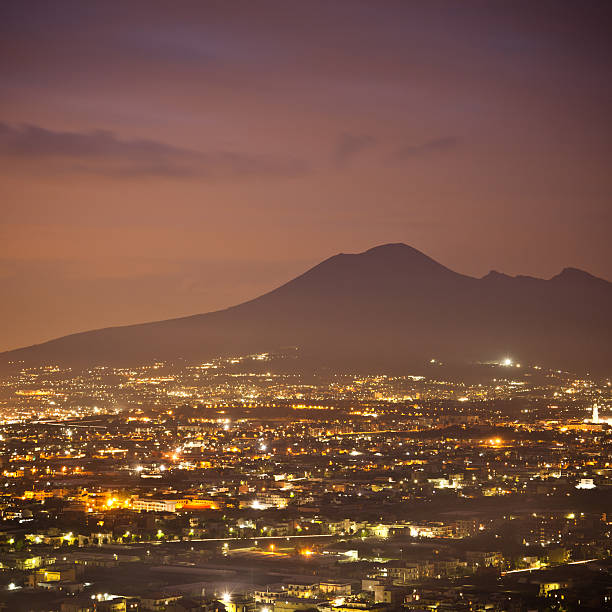 Naples (Napoli, Campania, Italy) By Night With Volcano Vesuvio as background. Long exposure, city traffic lights and clouds in motion.