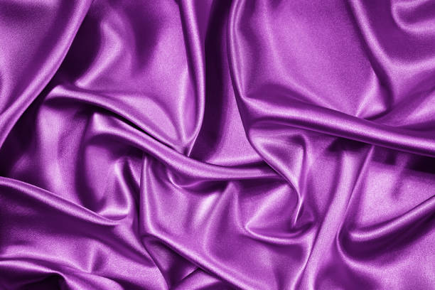 istock Purple pink silk satin. Folds on shiny fabric surface. Beautiful  background 1368929496