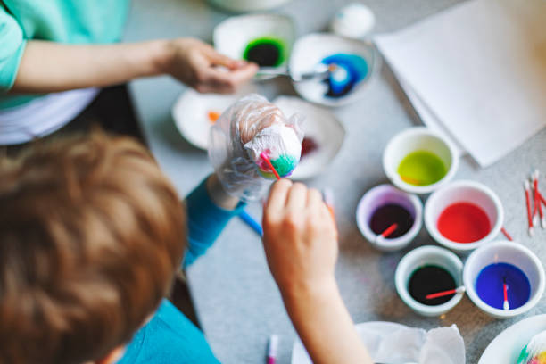 Mother and son painting eggs for Easter