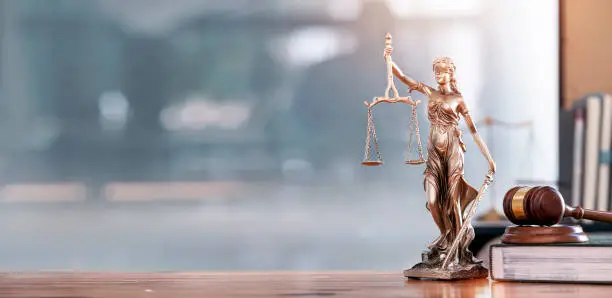 Photo of Legal and law concept. Statue of Lady Justice with scales of justice and wooden judge gavel on wooden table. Panoramic image statue of lady justice.