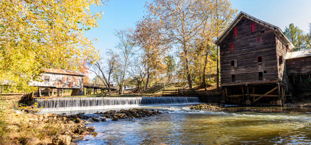 Childersburg, Alabama, USA - Nov. 14, 2021: Historic mill and covered bridge on Talladega Creek at Kymulga Grist Mill and Park. These structures built in 1860s are over 140 years old and still located where originally built.