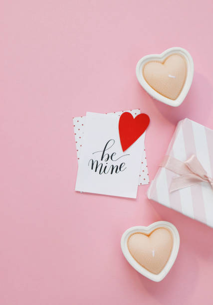 istock Happy Valentines Day composition. Blank greeting card mockup, gift boxes, red hearts, confetti on pink background 1368935447