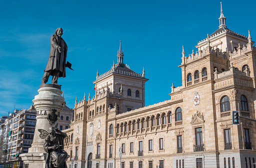 Statue to the writer and poet José Zorrilla with the building of the cavalry academy in the background in the city of Valladolid, Spain