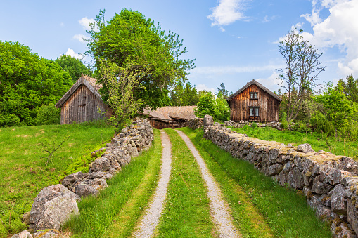 Vara, Sweden - June 10, 2016: Idyllic old farm houses on a hill with stone walls