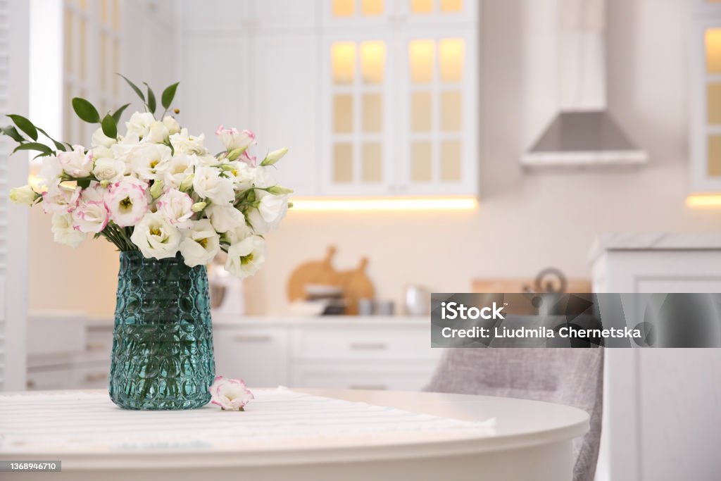 Bouquet of beautiful flowers on table in kitchen, space for text. Interior design Flower Stock Photo