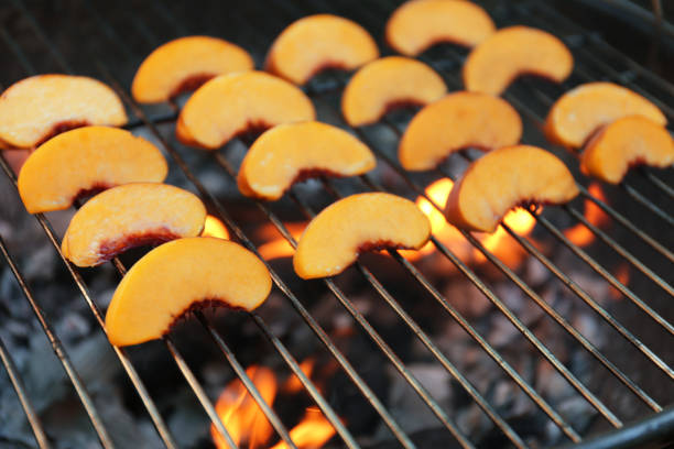 istock Modern grill with tasty peach slices, closeup 1368947042