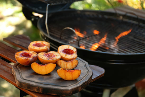 deliziose pesche grigliate su tavolo di legno all'aperto - dessert grilled peaches peach foto e immagini stock
