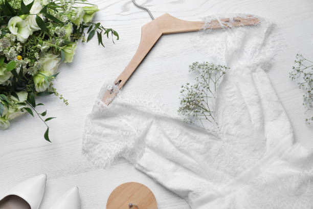 Beautiful wedding dress, engagement ring and flowers on white wooden background, flat lay Beautiful wedding dress, engagement ring and flowers on white wooden background, flat lay wedding dresses stock pictures, royalty-free photos & images