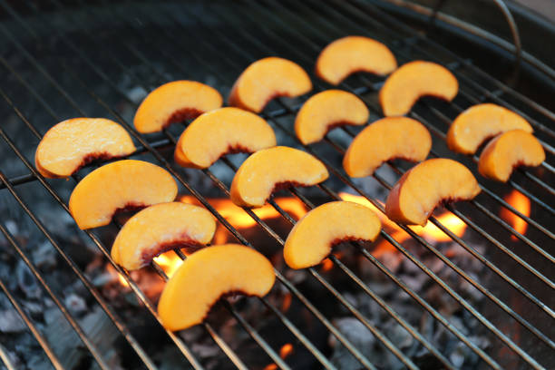 istock Modern grill with tasty peach slices, closeup 1368948652