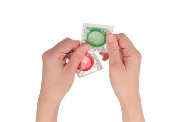 istock Condom in woman hand isolated on white background. 1368948880
