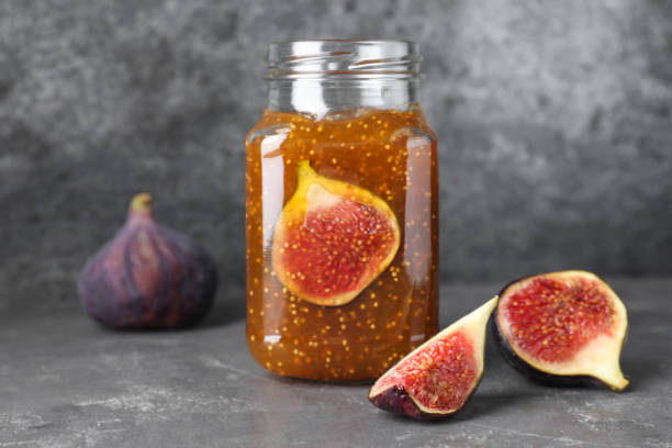 istock Delicious fig jam and fresh fruits on grey table 1368949949