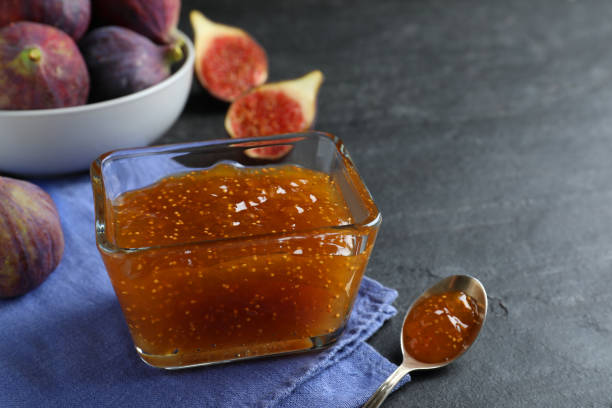 istock Delicious fig jam in glass bowl on black table, closeup 1368949951