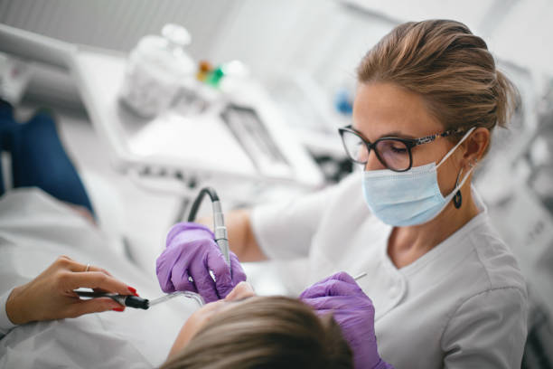 dentista reparando los dientes del paciente en el consultorio dental. - dental drill fotografías e imágenes de stock