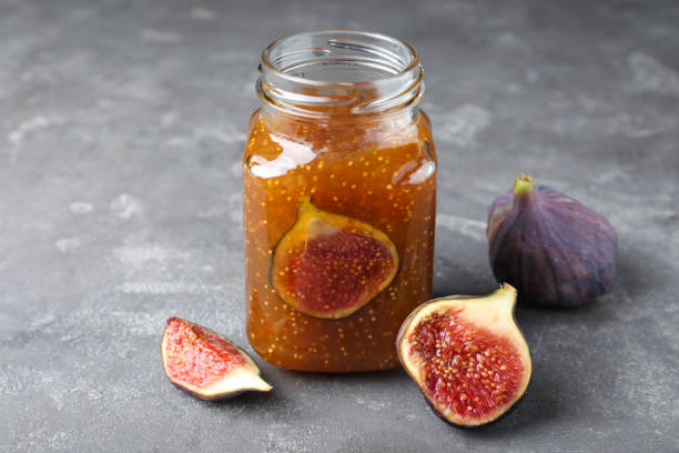 istock Delicious fig jam and fresh fruits on grey table 1368950323