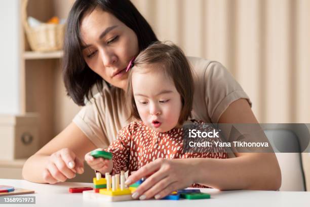 Social Emotional Development Of Children With Down Syndrome The Girl Plays In The Classroom With Educational Toys Stock Photo - Download Image Now