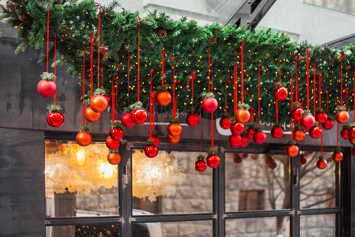 New Year red balls decorate the facade of the hotel and shop - Christmas street decor sets the mood for the holiday