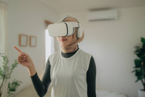 istock Young woman with VR headset exploring virtual reality 1368953681