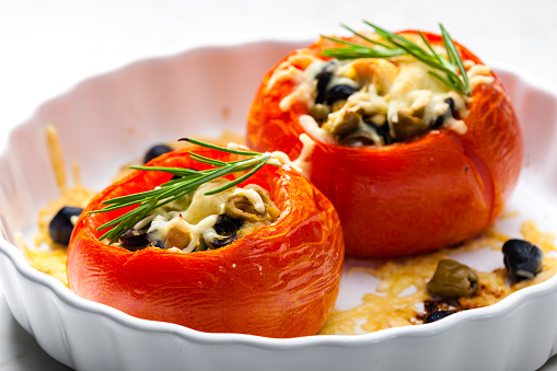 baking tomatoes filled with green and black olives and cheese