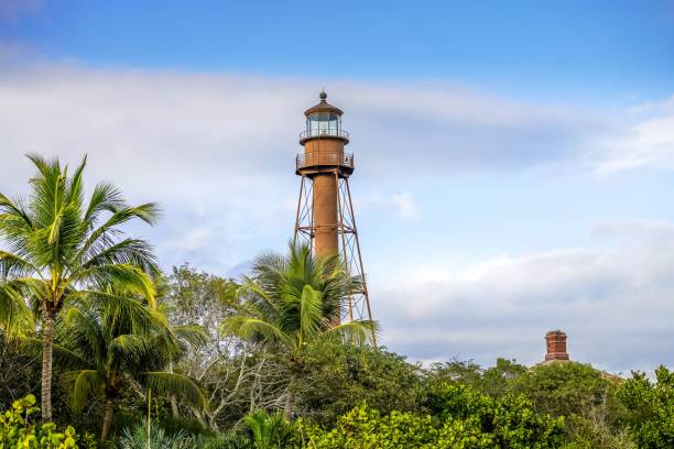Scenic view of lighthouse on Sanibel Island with blue sky and puffy white clouds stock photo