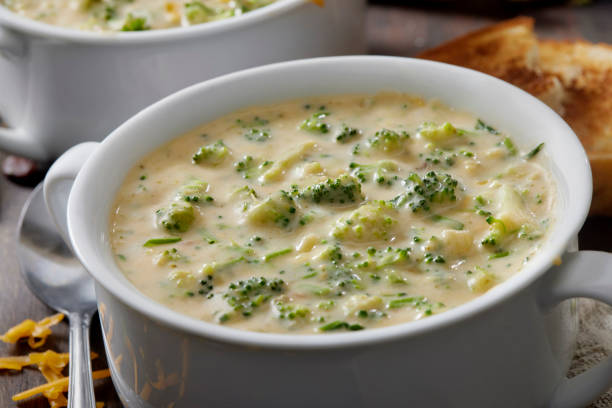 Creamy Broccoli and Cheddar Soup Creamy Broccoli and Cheddar Soup with Ripple Potato Chips cheese sauce stock pictures, royalty-free photos & images