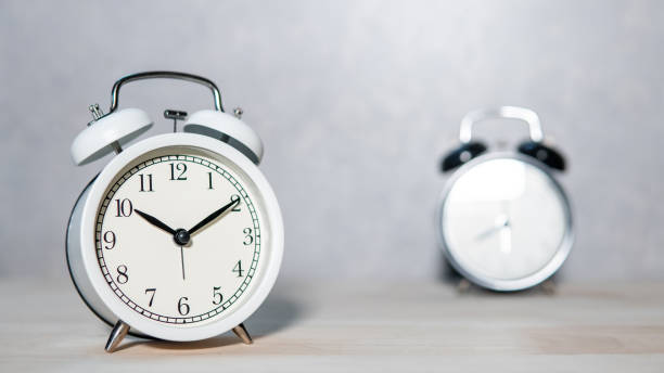 istock White and black classic alarm clock on wooden table 1368961019
