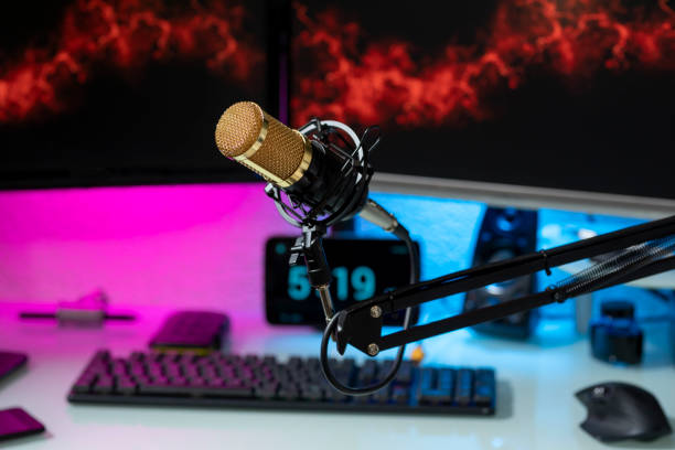 istock Professional microphone with gamer setup in the background and colored lights 1368961063