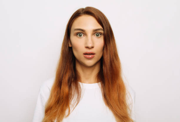 istock Young redhead woman looking at the camera in surprise 1368961321