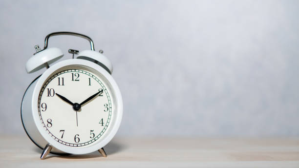 istock White retro alarm clock on wooden table 1368961492