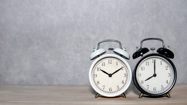 istock White and black classic alarm clock on wooden table 1368961494