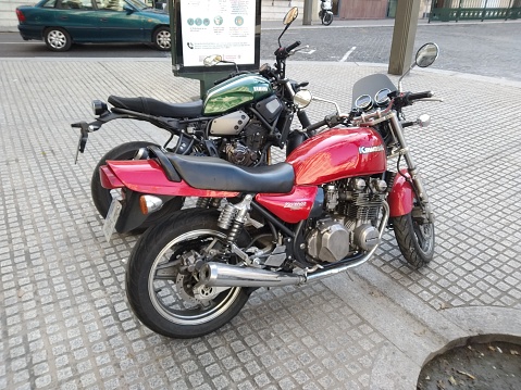 January 27th 2022 - Alcoy, Alicante. Red kawasaki and green yamaha motorbikes parked at the street. High quality photo