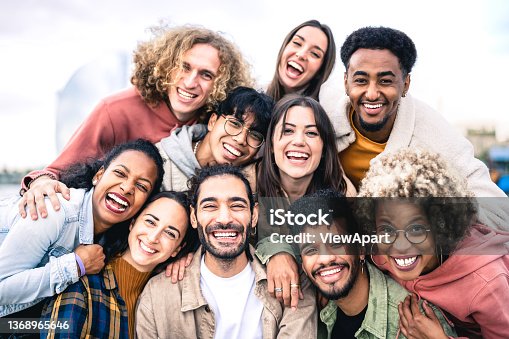 istock Multi ethnic guys and girls taking selfie outdoors with backlight - Happy life style friendship concept on young multicultural people having fun day together in Barcelona - Bright vivid filter 1368965646